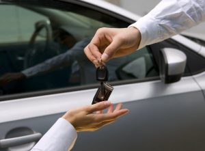 man giving car keys to woman